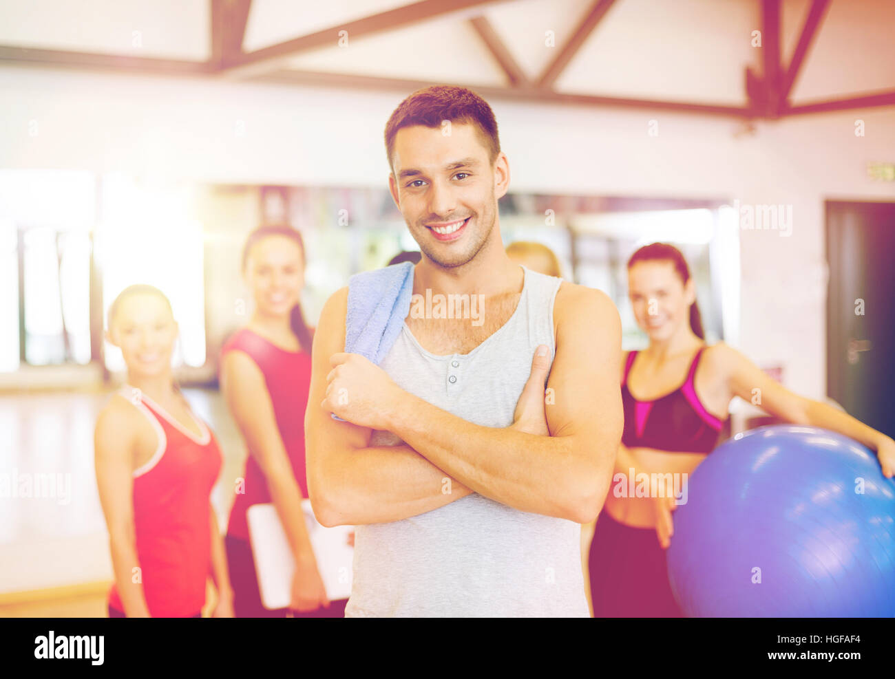 smiling man standing in front of the group in gym Stock Photo - Alamy