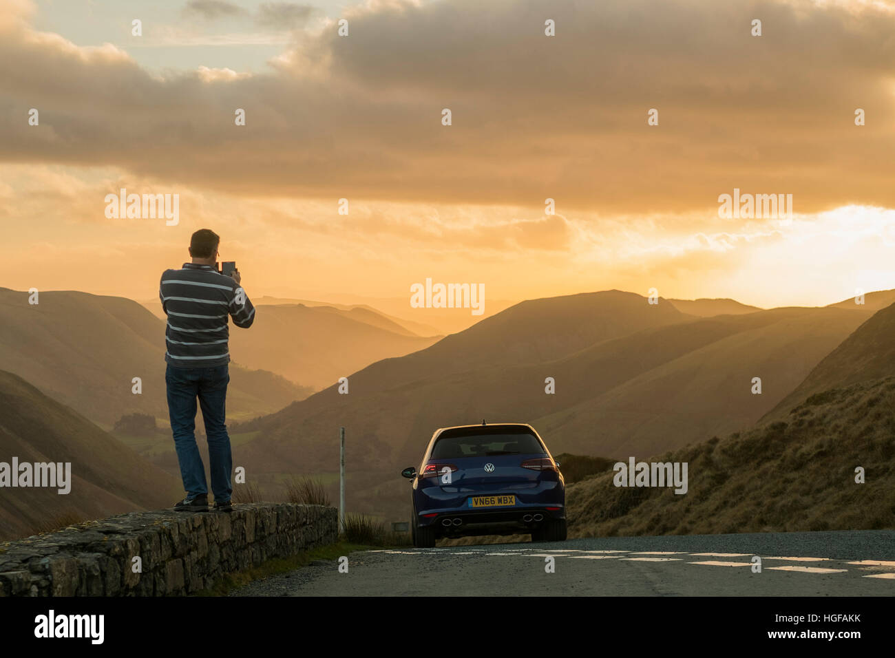 A man taking a photograph on his smartphone of the veiw at Bwlch y Groes, the highest mountain road pass in Wales, on the back road between Bala (Gwynedd)  and Dinas Mawddwy (Powys) Stock Photo