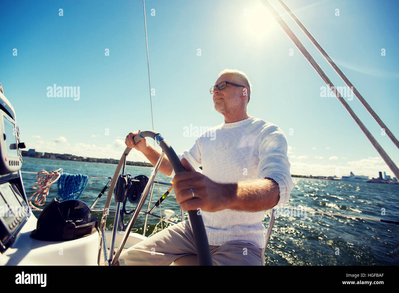 senior man at helm on boat or yacht sailing in sea Stock Photo - Alamy