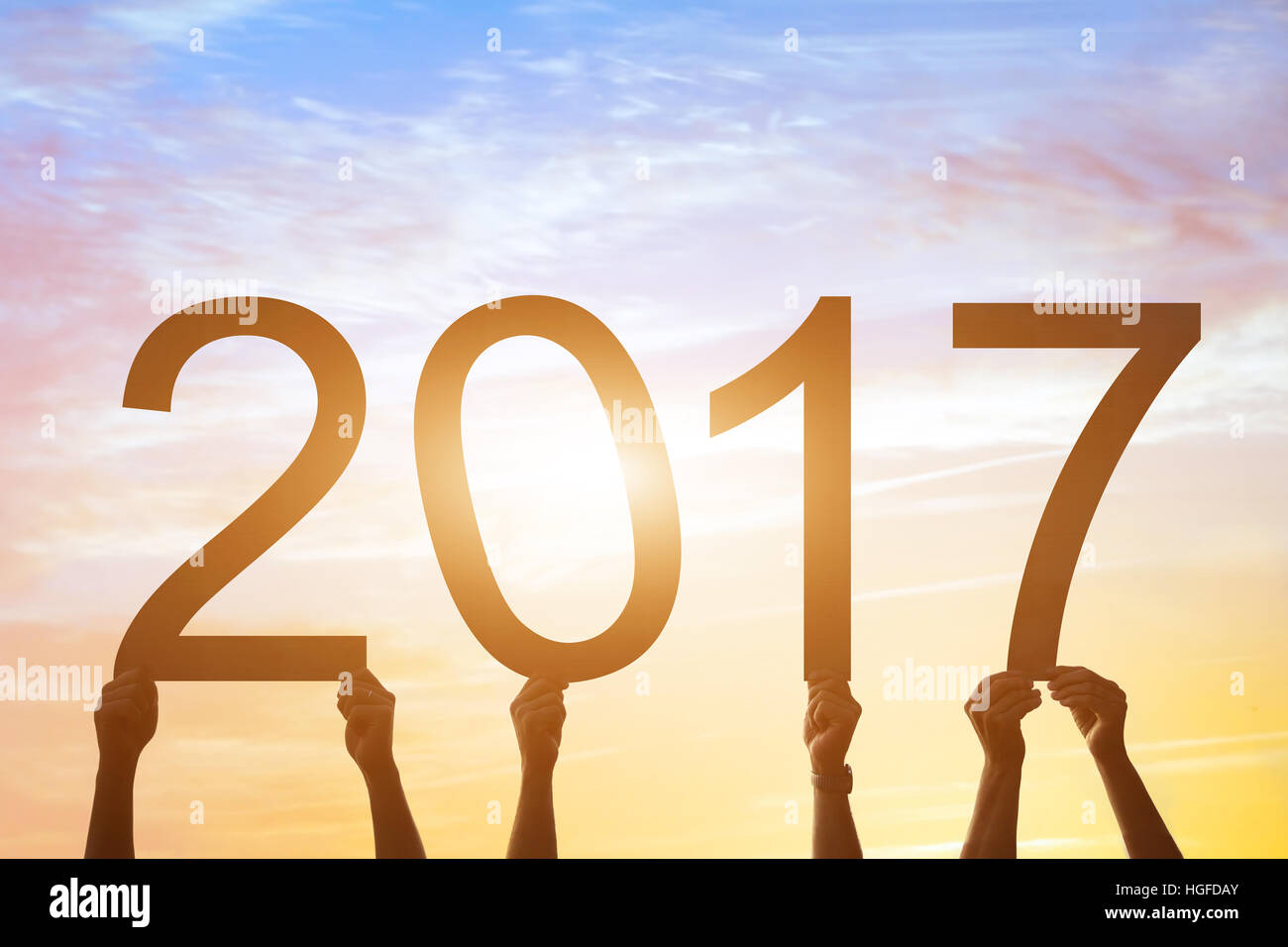 2017 sign, beautiful card about new year, silhouettes of hands holding digits at sunset sky Stock Photo