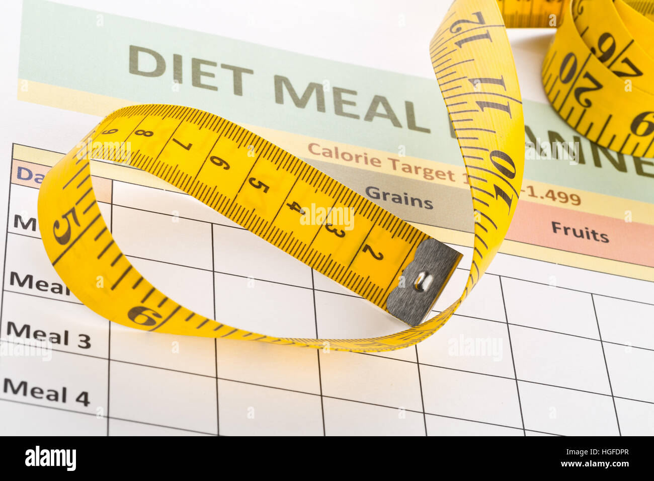Measurement tape on diet meal planner sheet - dieting or weight loss concept Stock Photo