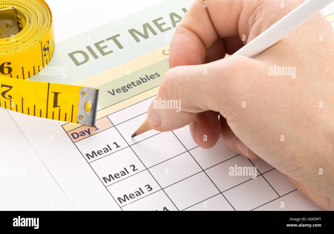 Man filling out diet meal planner sheet - dieting or weight loss concept Stock Photo