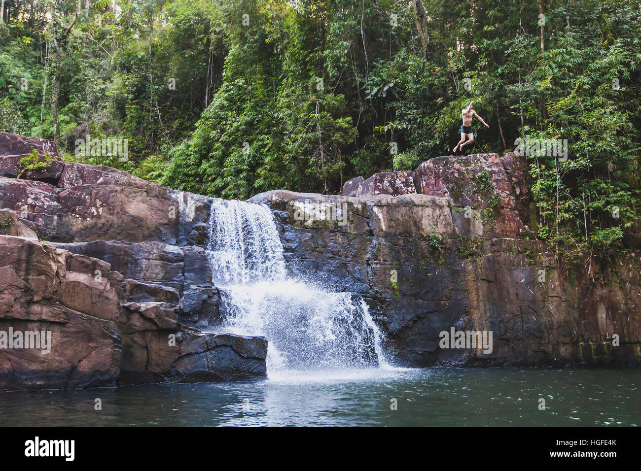 adventure, brave man jumping to the waterfall, canyoning or extreme sport, bravery concept Stock Photo