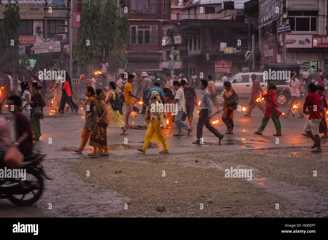 Nepal - circa May 2012: Protesting people walk on street on rainy day and hold burning torches during Nepal general strike. Documentary editorial. Stock Photo