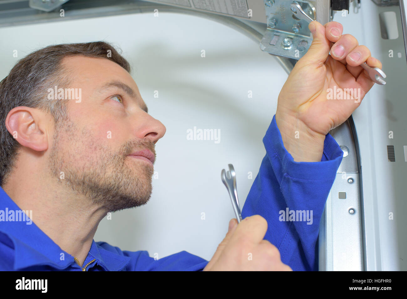 Fixing a garage door hinge Stock Photo Alamy