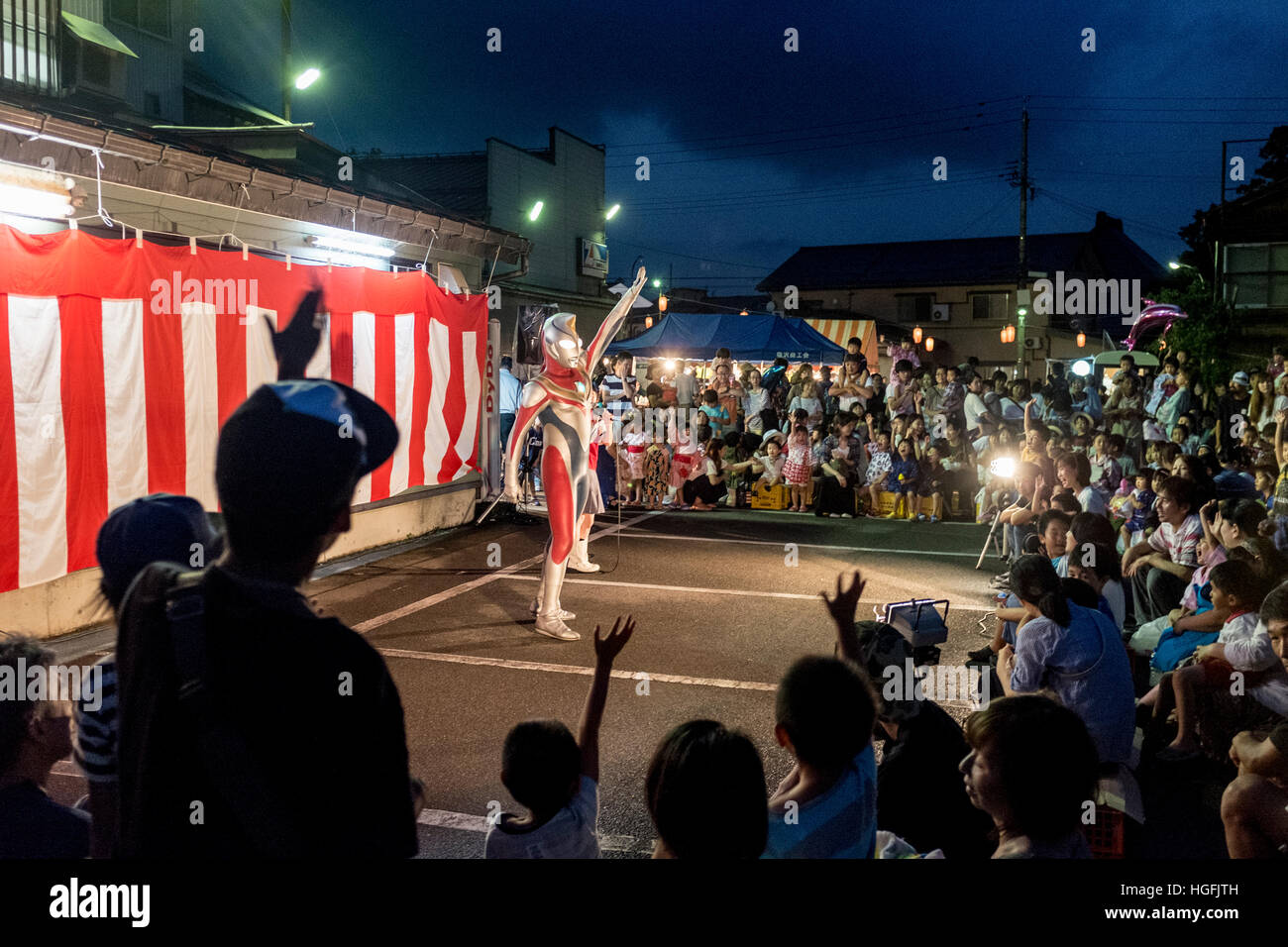 Ultraman performs for children during a summer festival in Shiozawa, Niigata, Japan Stock Photo