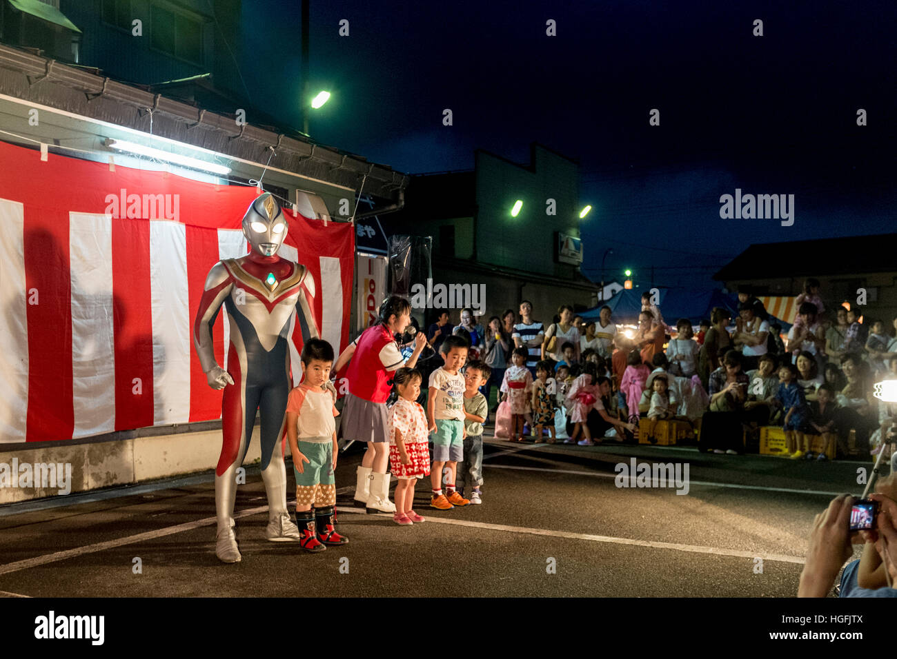 Ultraman performs for children during a summer festival in Shiozawa, Niigata, Japan Stock Photo