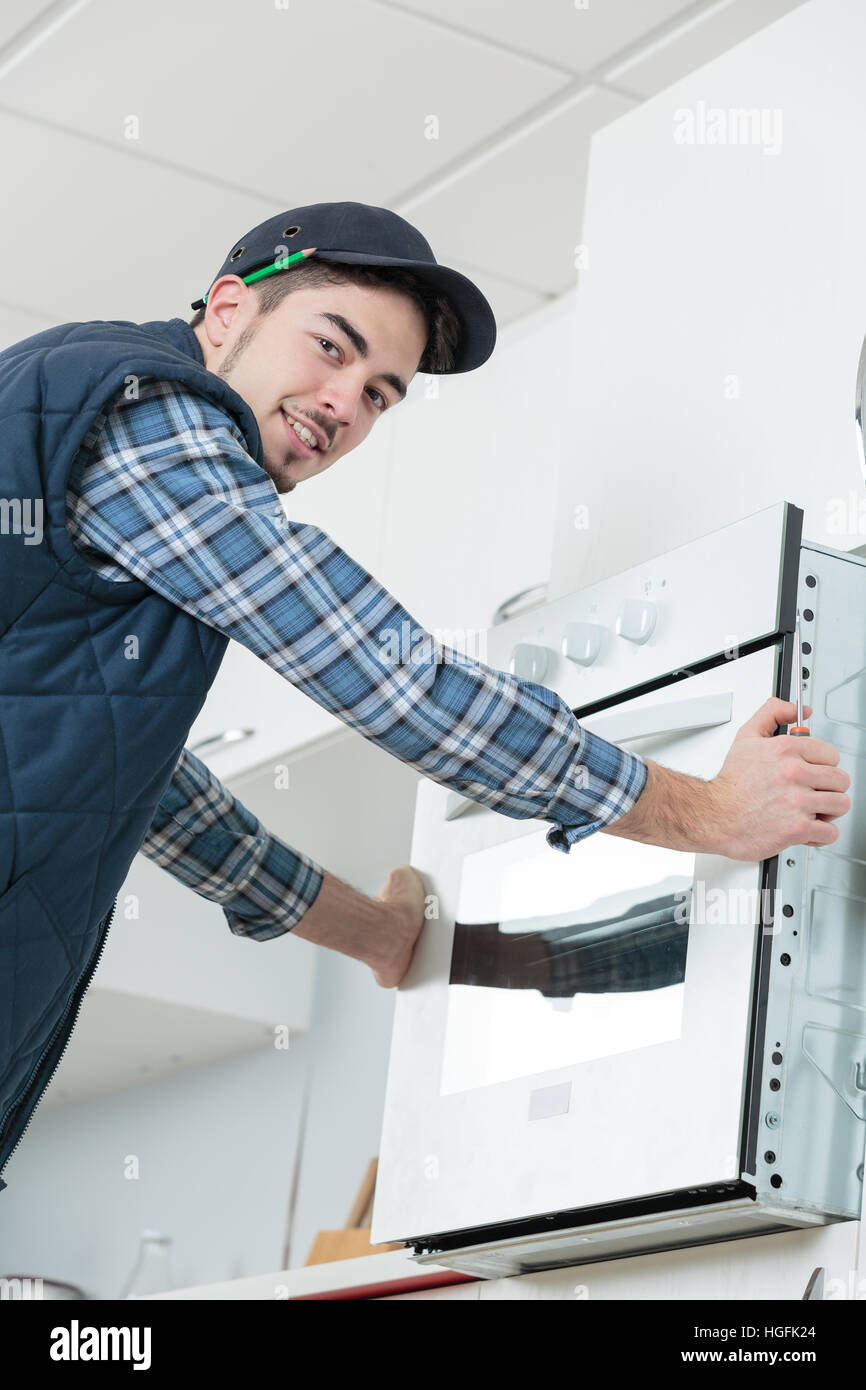 builder installing built-in electric oven Stock Photo