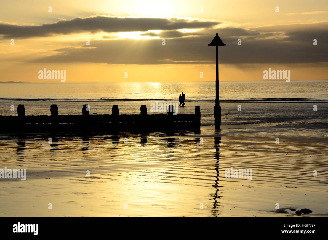 Walkers couple on Borth Beach at sunset  Ceredigion Wales Cymru UK GB Stock Photo