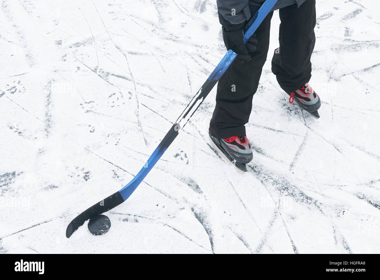 Outdoor Ice skating. Hockey player's legs and skates on ice rink. Stock Photo