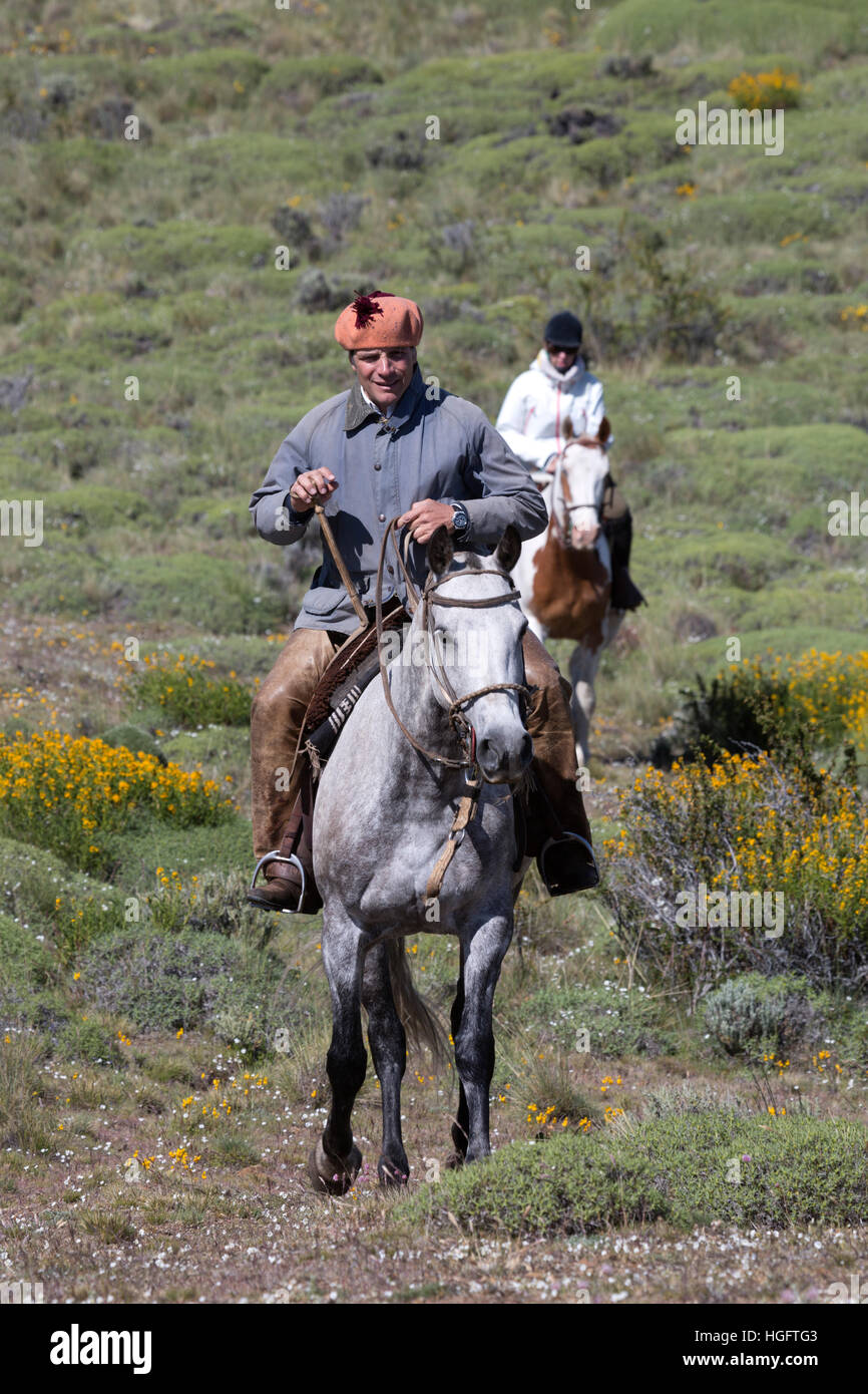 Gaucho guide and tourist on horse at Estancia Alta Vista, El Calafate, Parque Nacional Los Glaciares, Patagonia, Argentina, South America Stock Photo