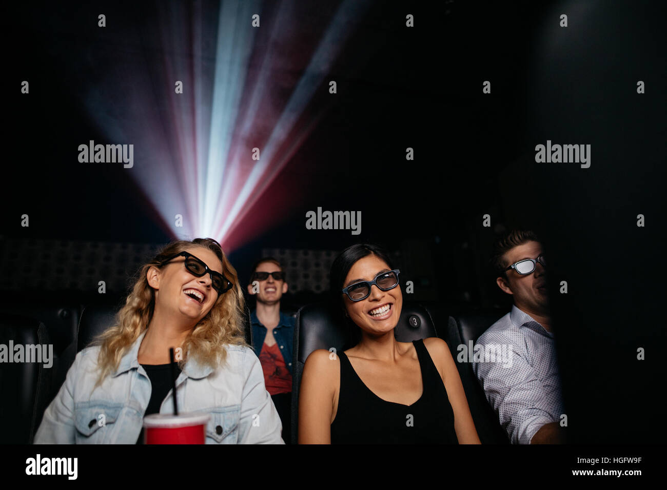 Young women watching 3d movie in cinema. People in theater with 3d