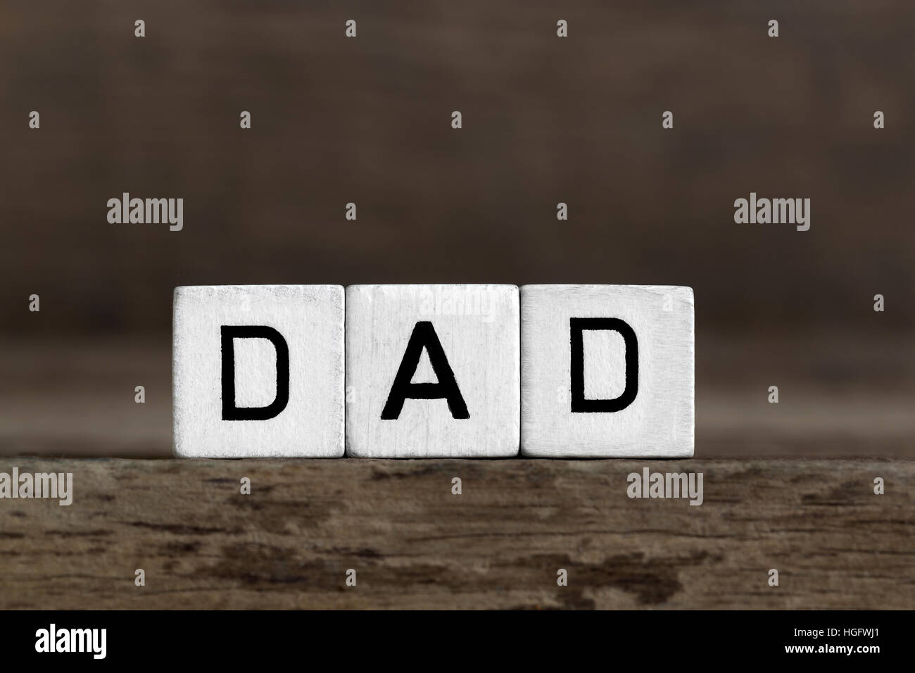 Dad, written in cubes on wooden background Stock Photo
