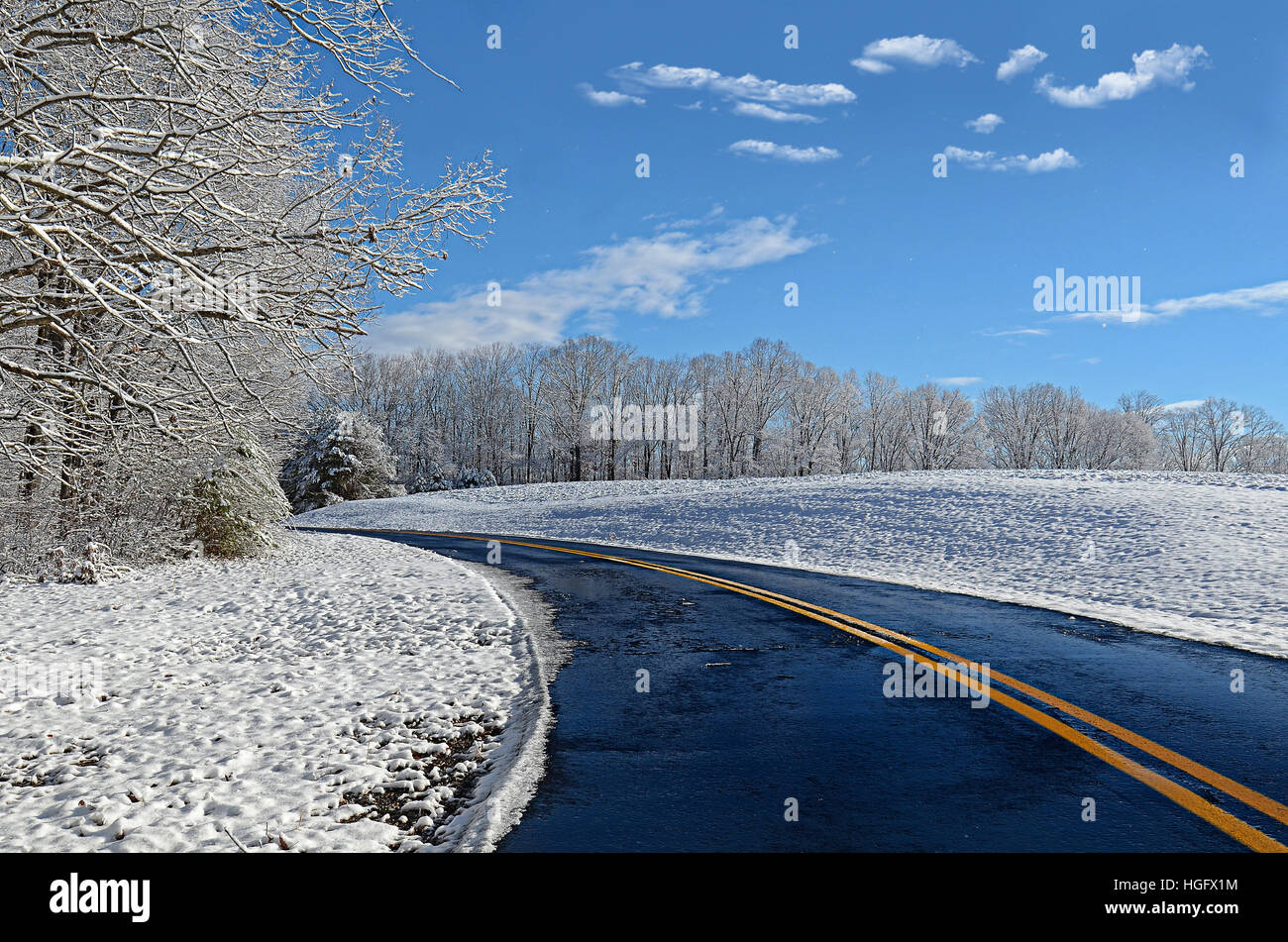 A slick curving road with winter landscape. Concept for travel, season, beauty in nature, peacefulness. Stock Photo