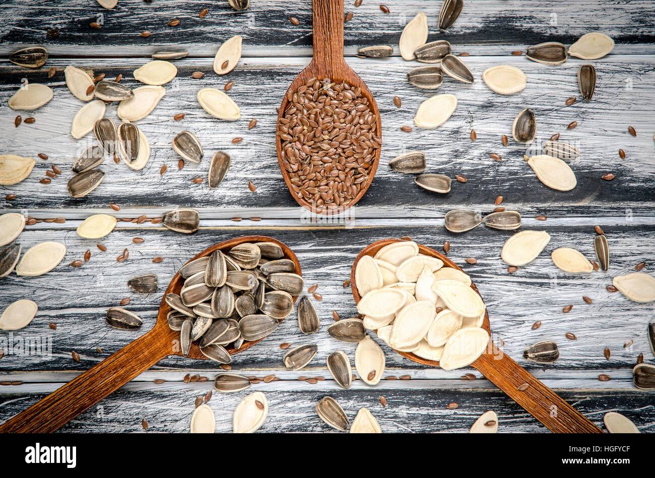 Sunflower, linseed and pumpkin seeds in wooden spoons. Stock Photo