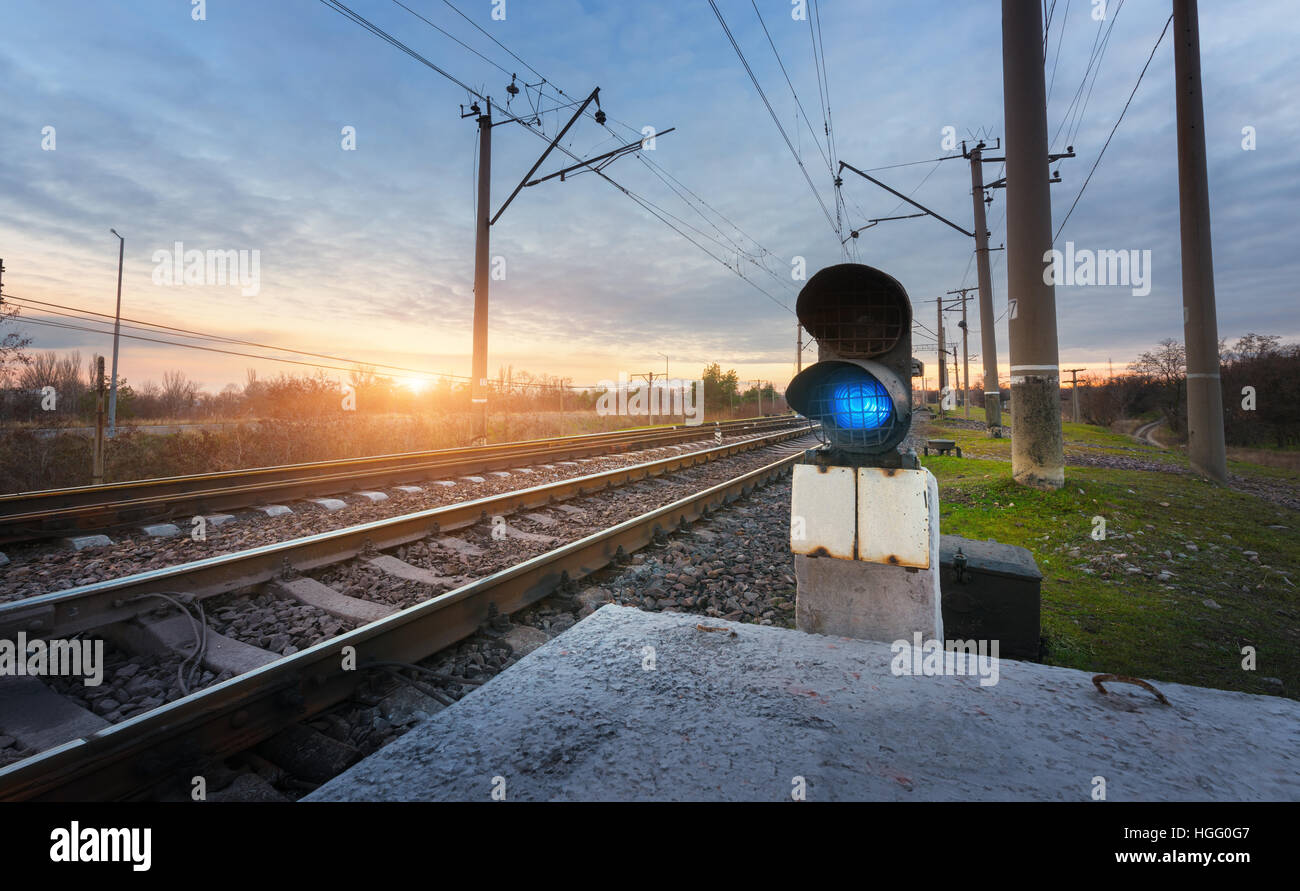 Railway station with semaphore against sunny sky with clouds at sunset. Colorful industrial landscape. Railroad.Railway platform Stock Photo