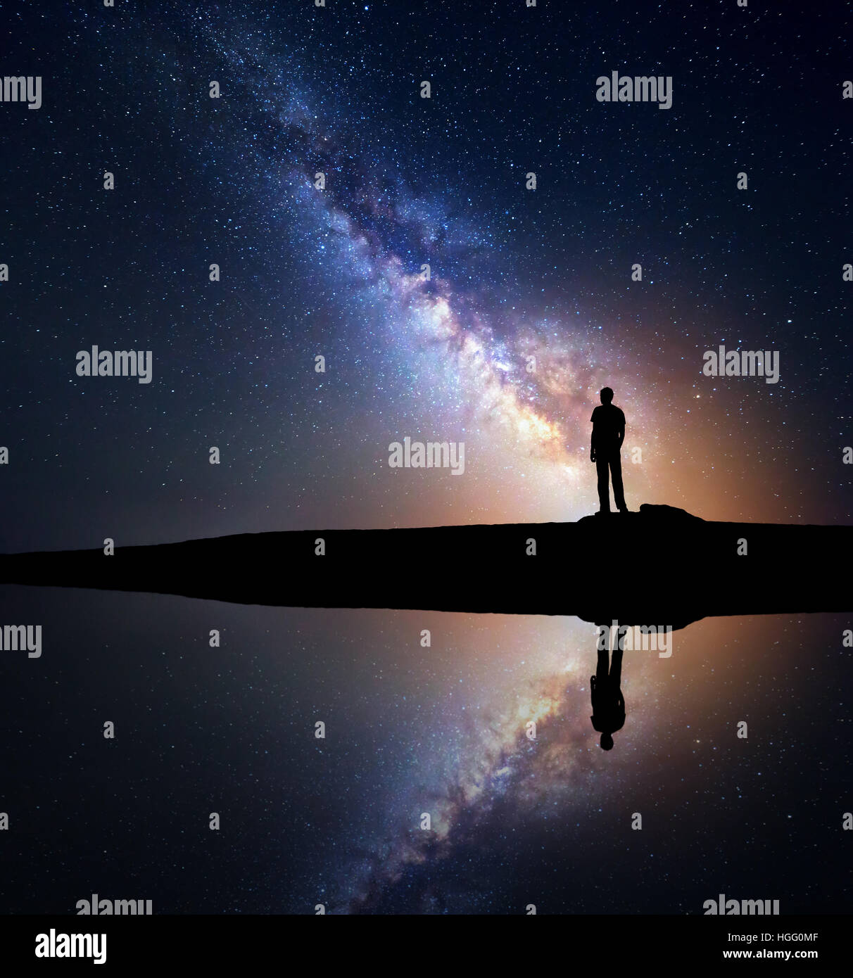 Night starry sky with Milky Way and silhouette of a standing man on the ...