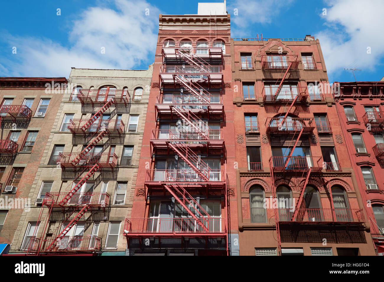Typical building facades with fire escape stairs, sunny day in Soho, New York Stock Photo