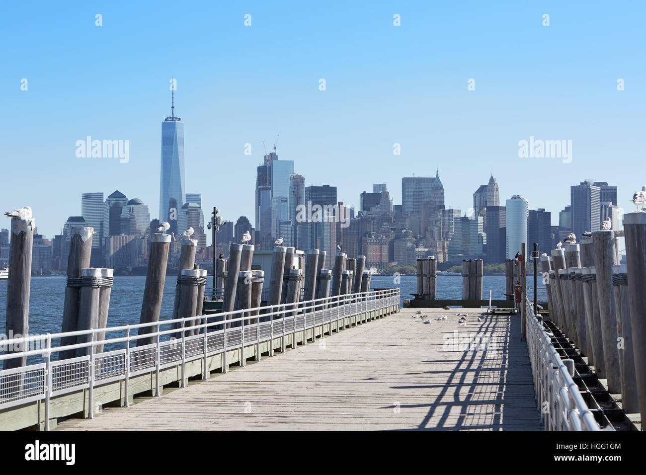New York city skyscrapers and empty pier with seagulls, sunlight Stock Photo