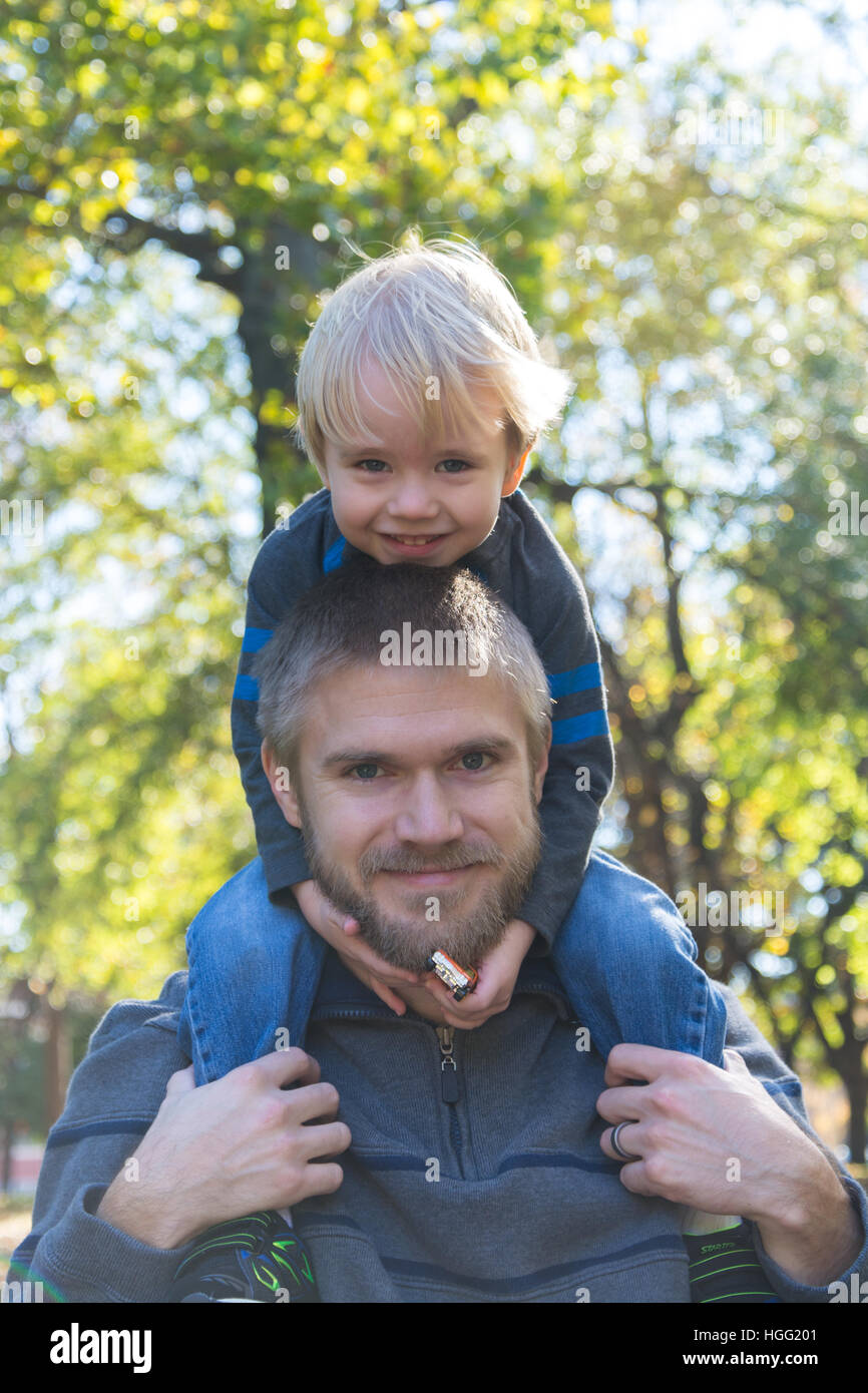 Young boy riding on his dad's shoulders. Stock Photo