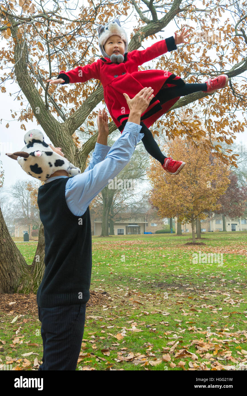Father throwing daughter up in the air. Stock Photo