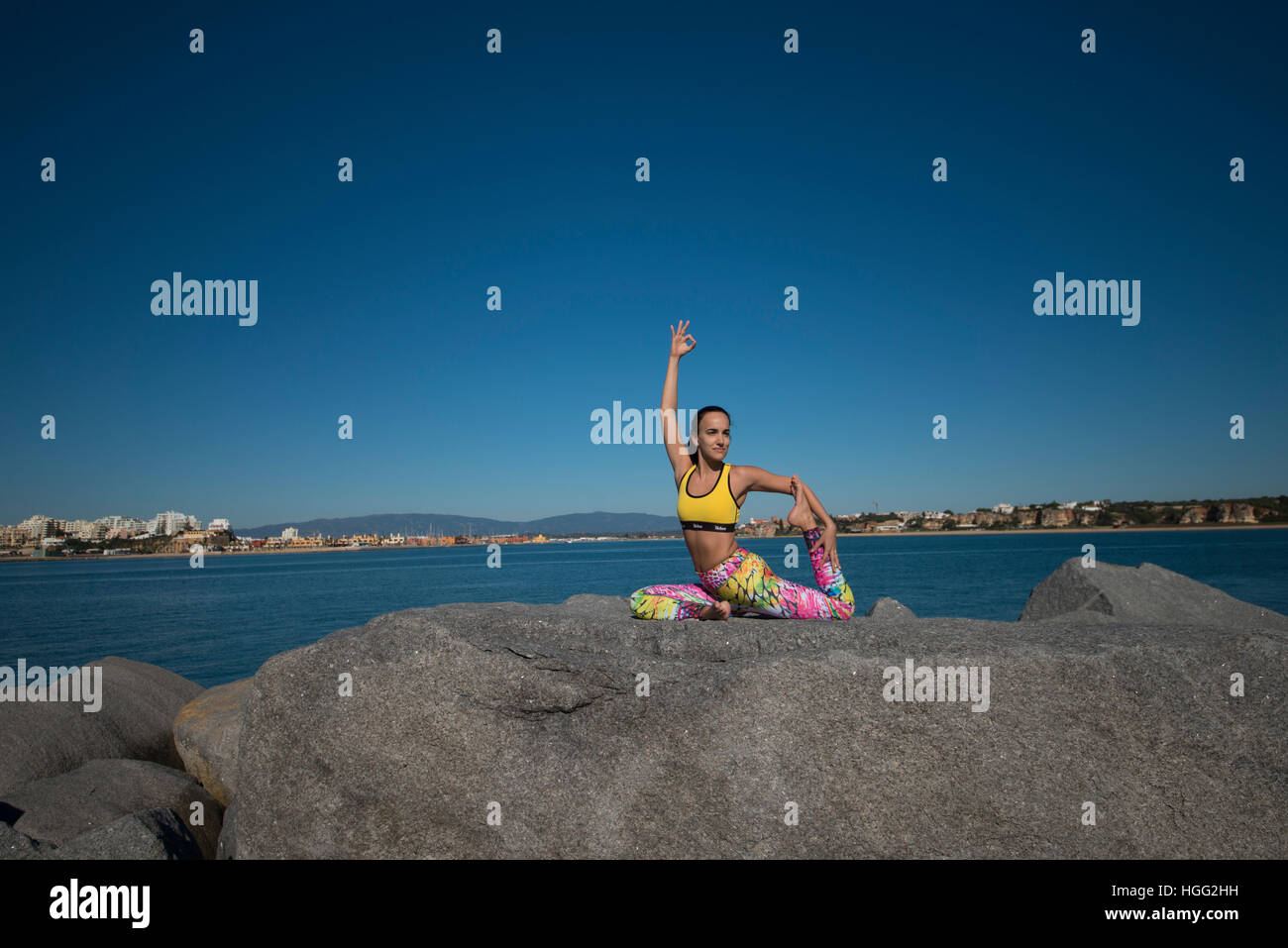woman doing yoga on a rock by the sea Stock Photo