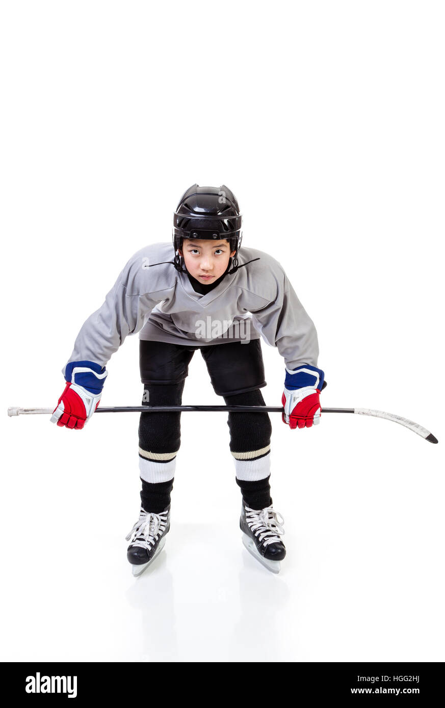 Junior ice hockey player with full equipment and uniform isolated on