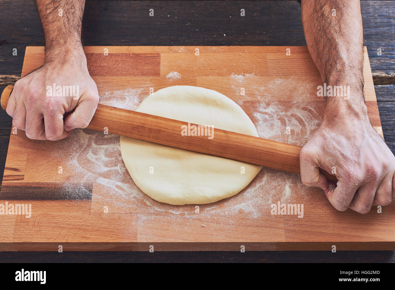 Making handmade pasta with wooden rolling pin Stock Photo