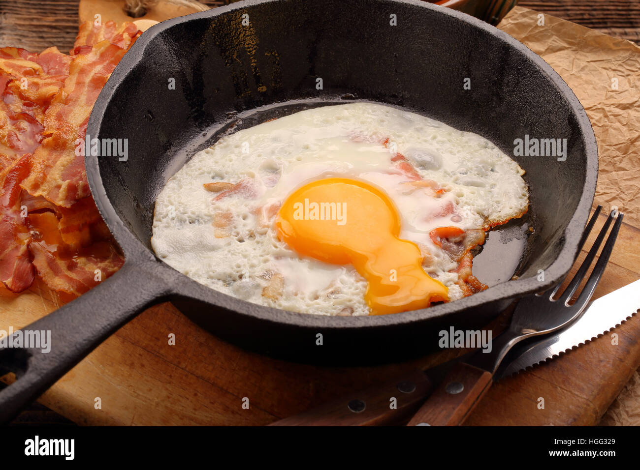 Fried egg with hot bacon pieces in a cast iron skillet Stock Photo Alamy