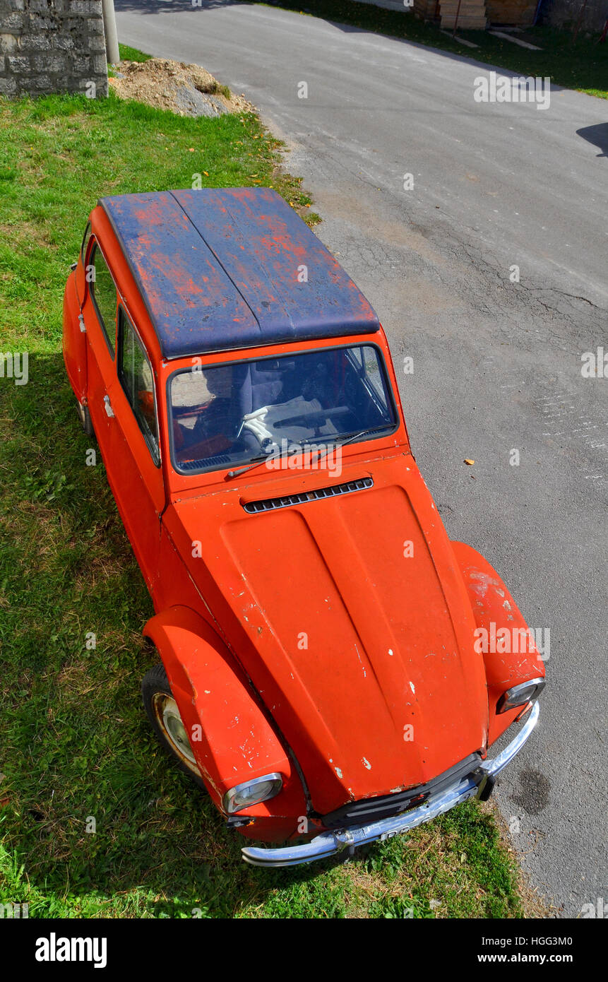 Red vintage Citroen Dyane car parked outside a village house in Montenegro. Stock Photo