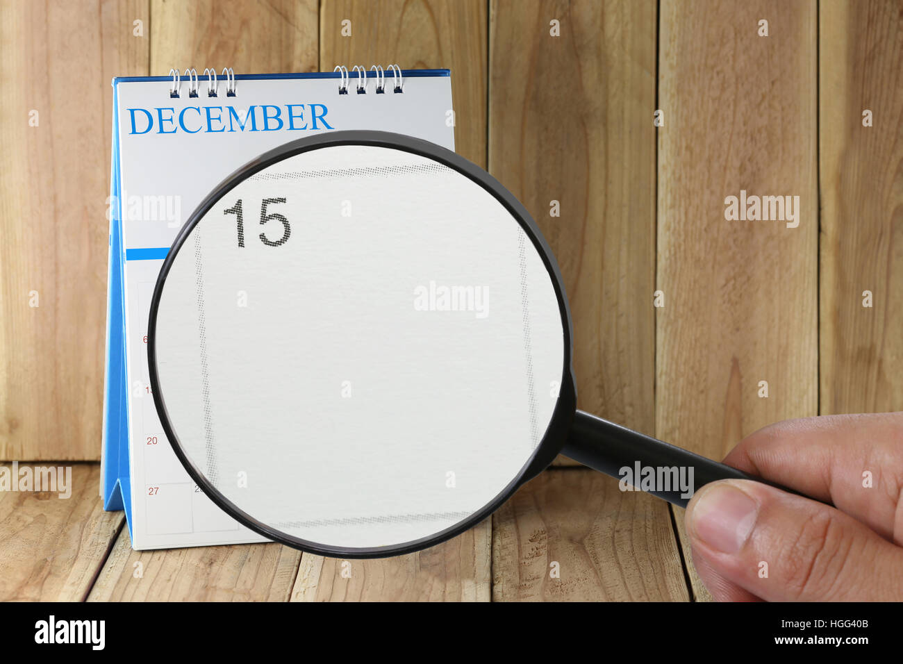 Magnifying glass in hand on calendar you can look Fifteenth day of month,Focus number fifteen in December,Concept in business and meetings. Stock Photo