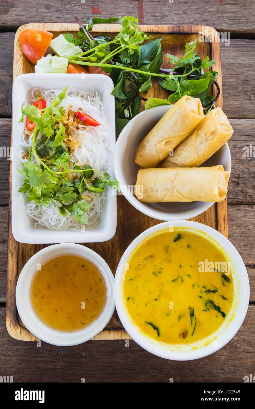 noodle and curry sauce with vegetable on wood table Stock Photo
