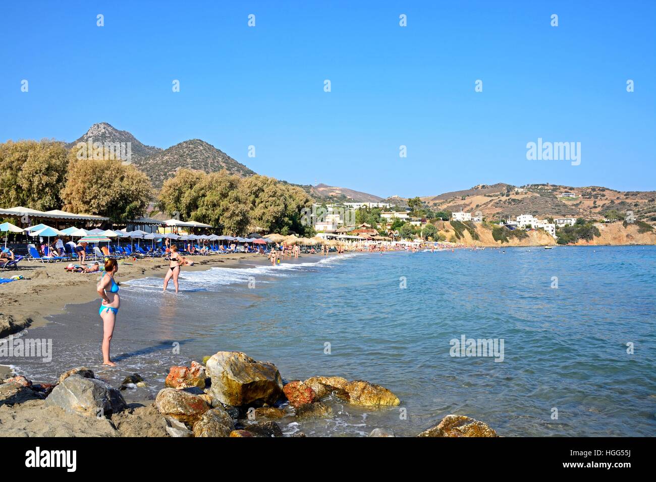 Tourists relaxing in the sea and on Livadi Beach with views along the coastline, Bali, Crete, Greece, Europe. Stock Photo