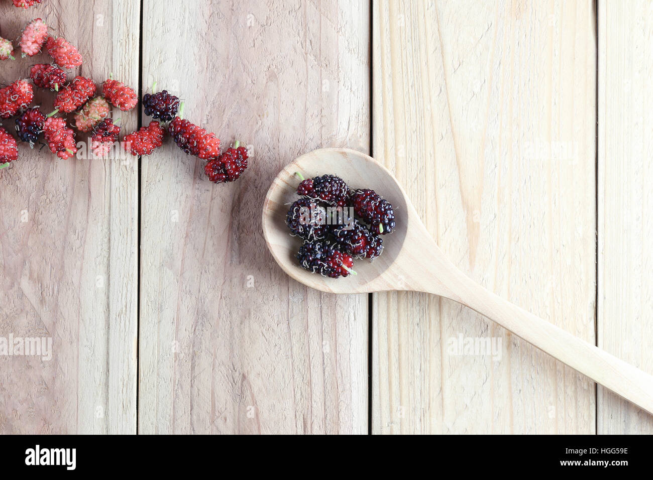 Mulberry fruit in wooden spoon on wood background,concept of healthy tropical fruit. Stock Photo