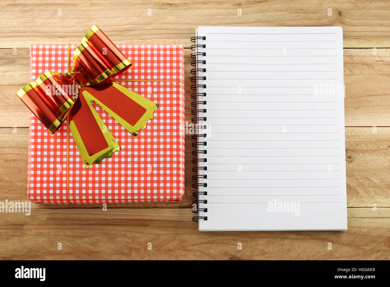 Red gift box with empty white book on wood background,concept of christmas and Important day. Stock Photo