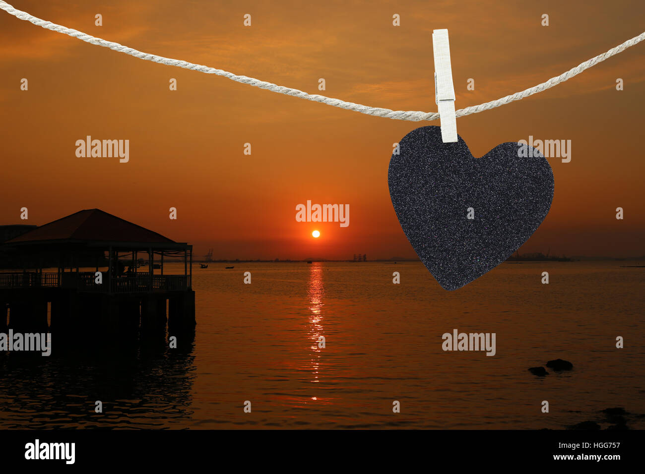 Black Heart hung on hemp rope on view sunset background and have copy space to manage the text you want. Stock Photo