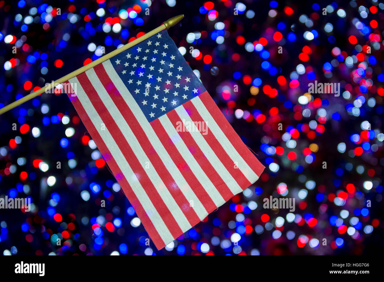 American flag hangs in front of patriotic red, white, and blue lights