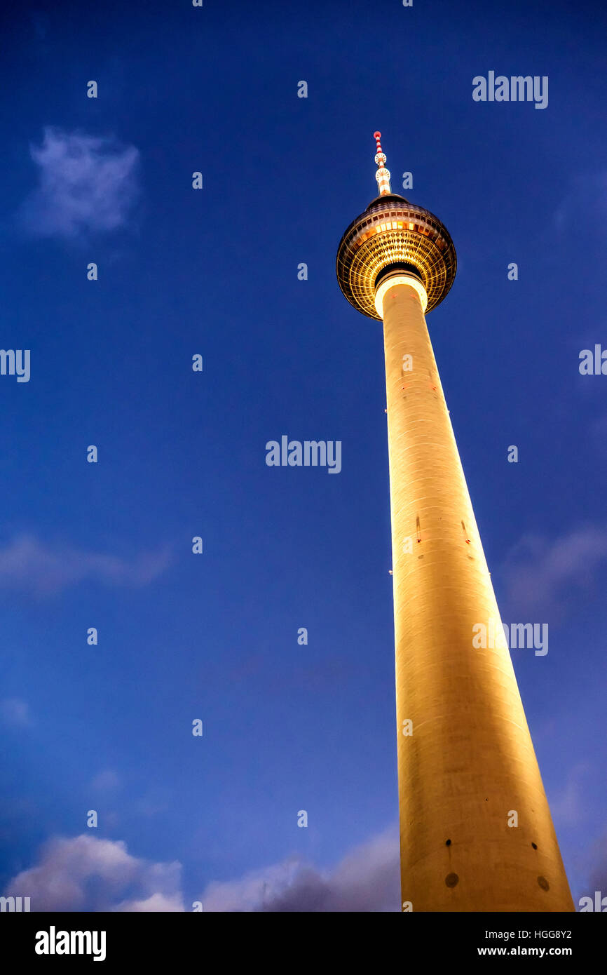 Berlin, Mitte.Alexanderplatz. Illuminated golden Television tower (fernsehturm) against dramatic evening sky Stock Photo