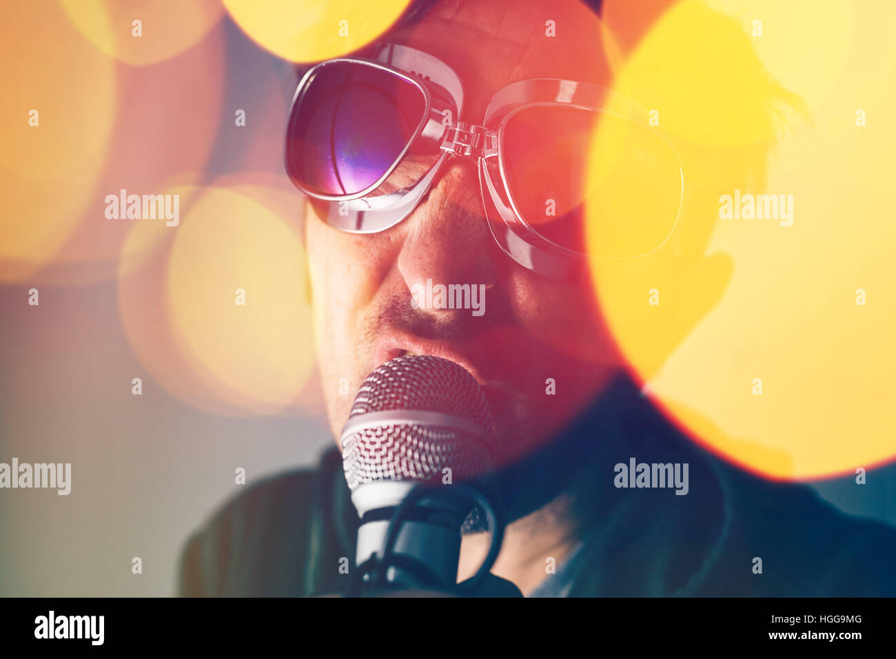 Alternative rock music singer singing song into microphone, bokeh light