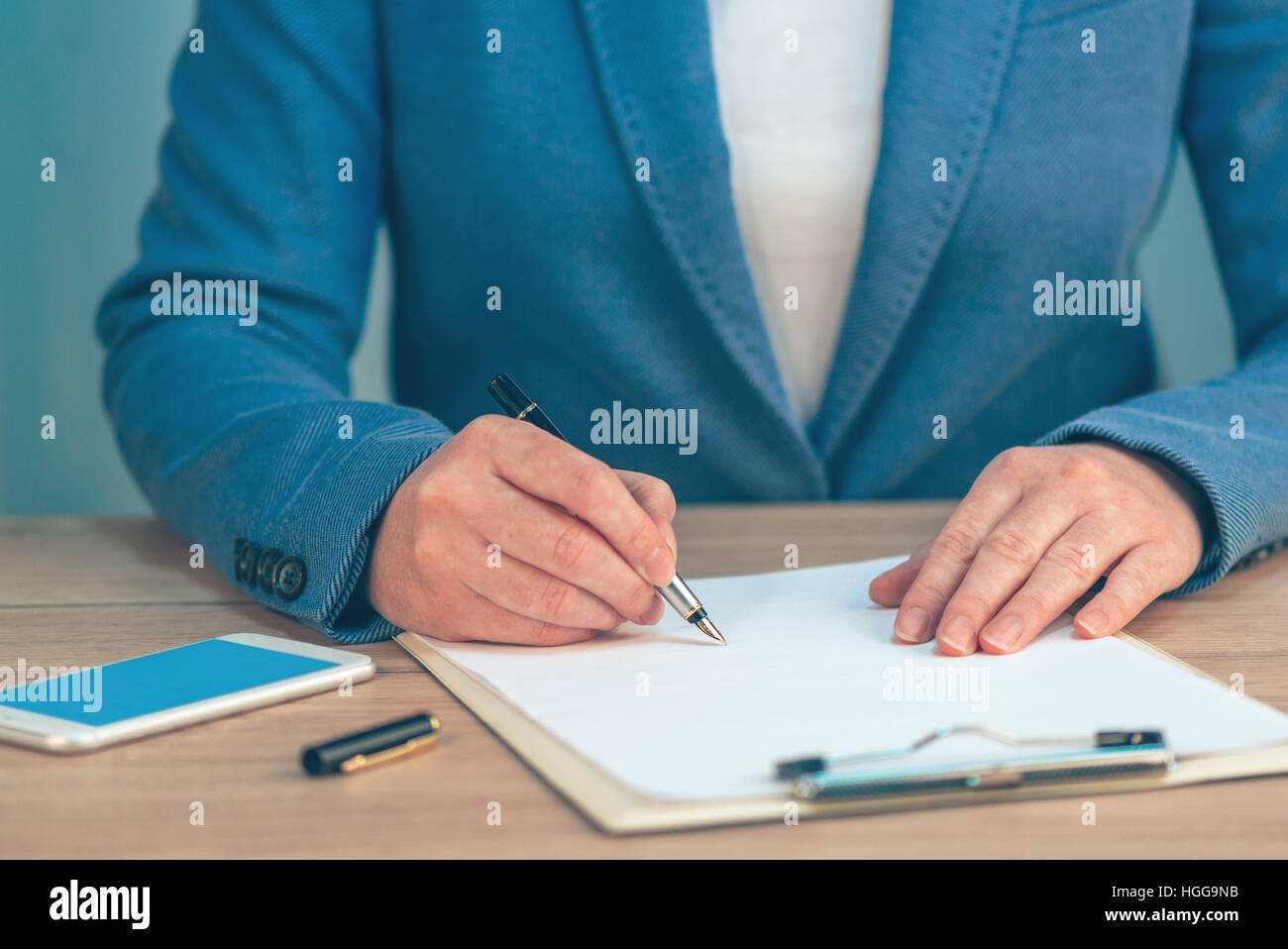 Businesswoman signing business contract agreement at office desk Stock Photo