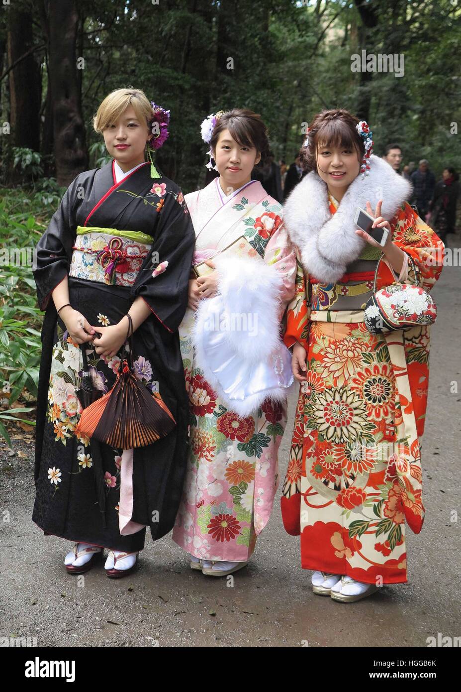 Tokyo, Japan. 8th Jan, 2017. Japanese women wearing kimonos pose in front  of the Meiji shrine in Tokyo, Japan, 8 January 2017. Young women who will  be 20 years of age between