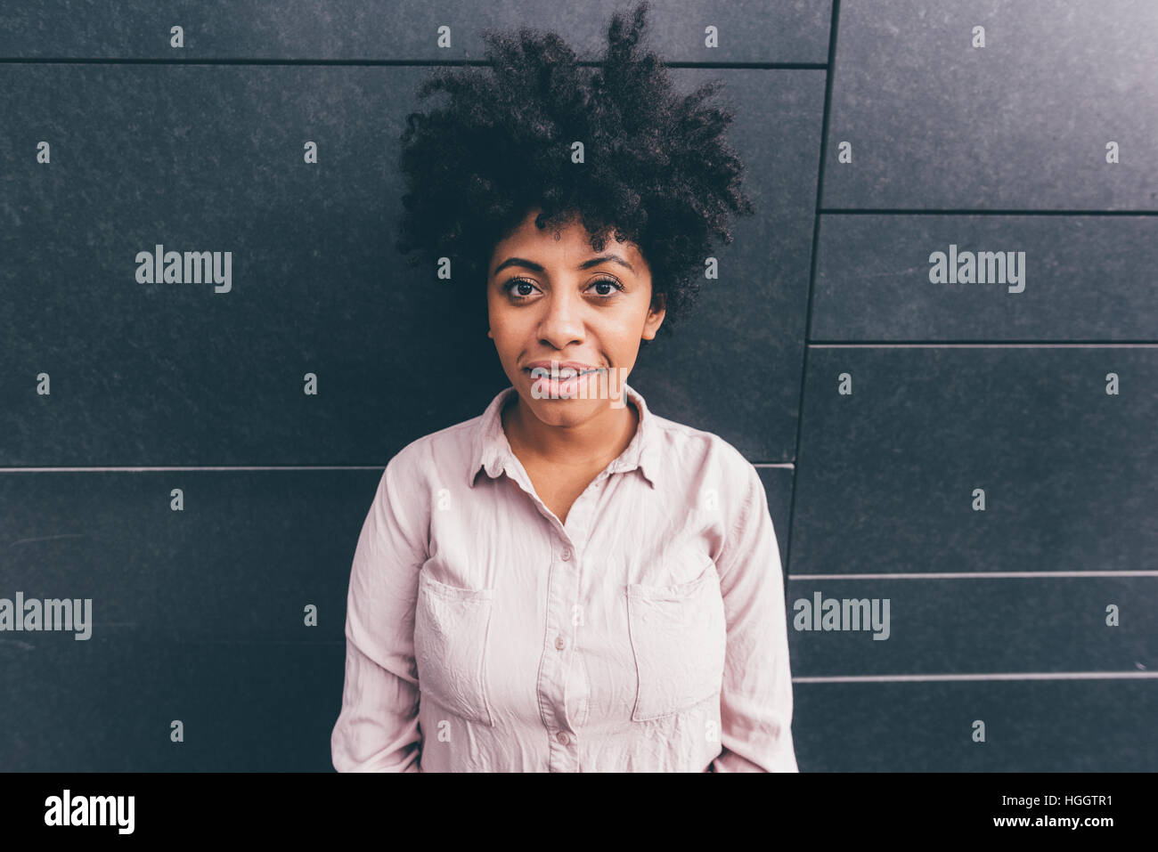 Portrait of young beautiful afro woman outdoor in the city having fun ...
