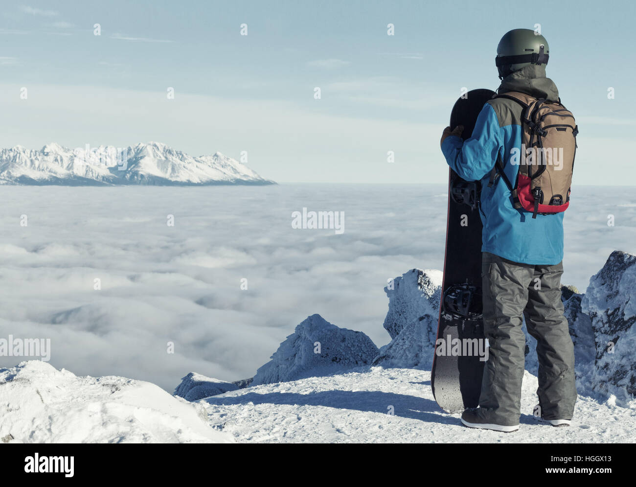 Man holding snowboard and taking a look at landscape at the top of the ...