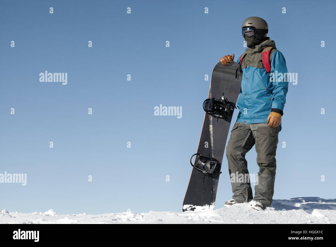 Man holding snowboard and taking a look at landscape from the top of ...