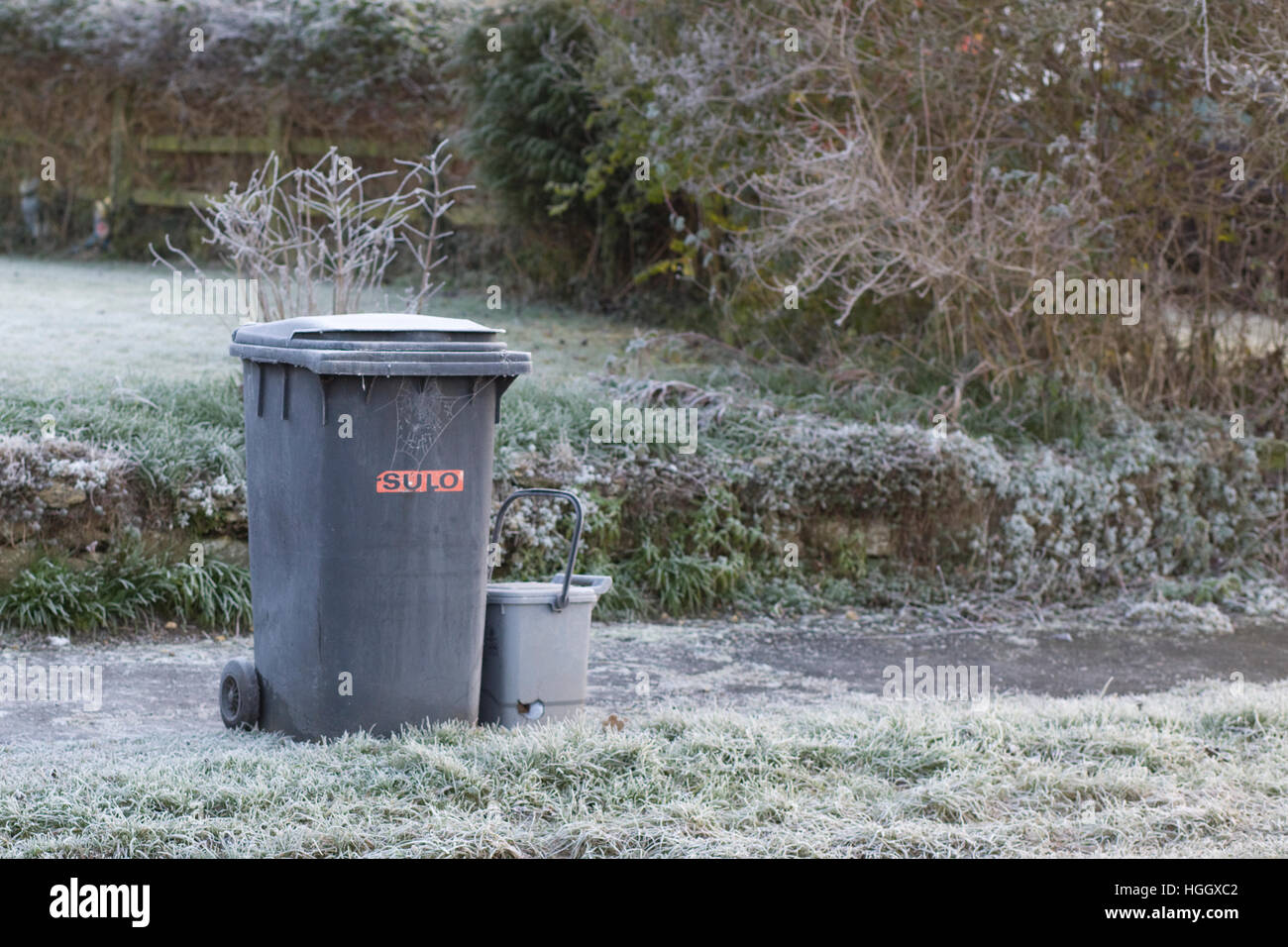 Frost-covered wheely bin and food recycling bin Stock Photo