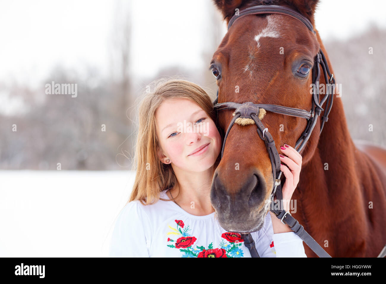 Young smiling girl enjoying friendship with horse Stock Photo