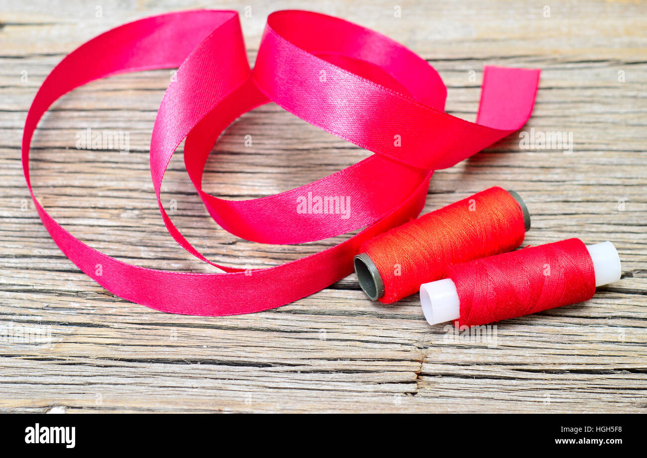 thread with ribbon on an old wooden surface Stock Photo - Alamy