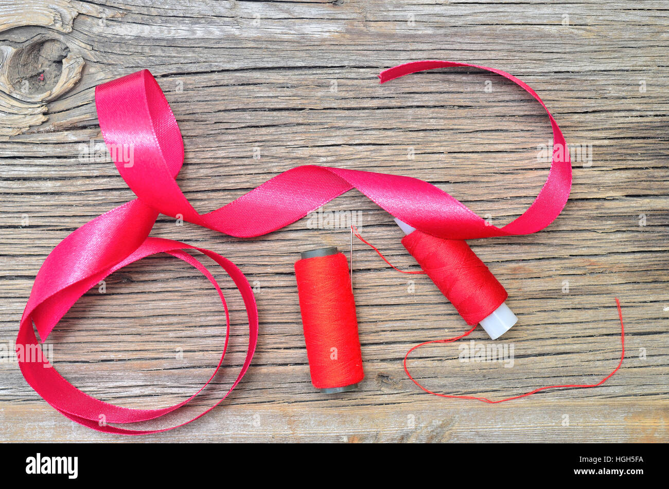 Threading With Ribbon thread with ribbon on an old wooden surface Stock Photo - Alamy