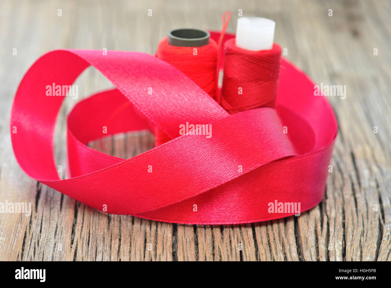 Threading With Ribbon thread with ribbon on an old wooden surface Stock Photo - Alamy