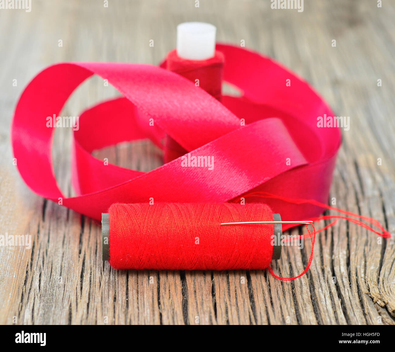 thread with ribbon on an old wooden surface Stock Photo - Alamy